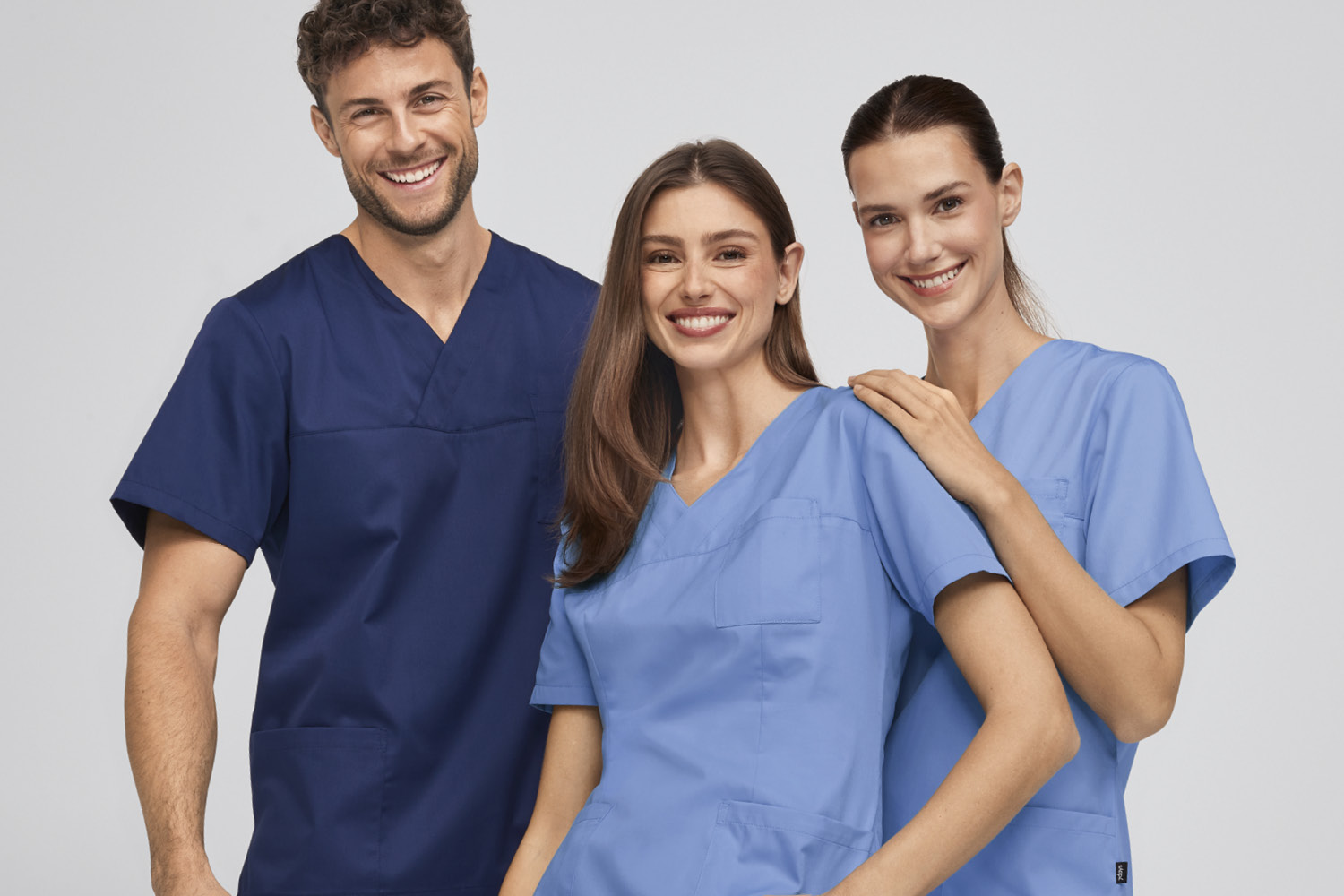 Tre personer i arbeidsklær fra 7days ser inn i kameraet